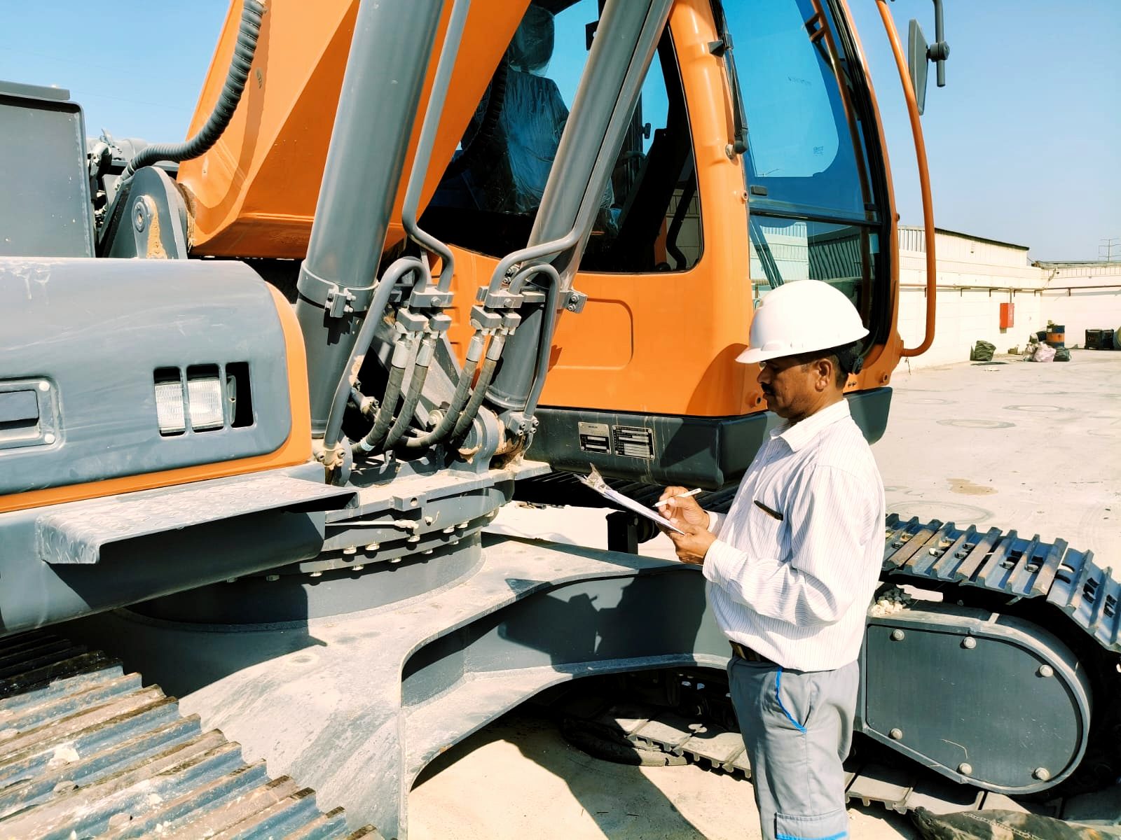 Supervisor inspecting equipment with a clipboard