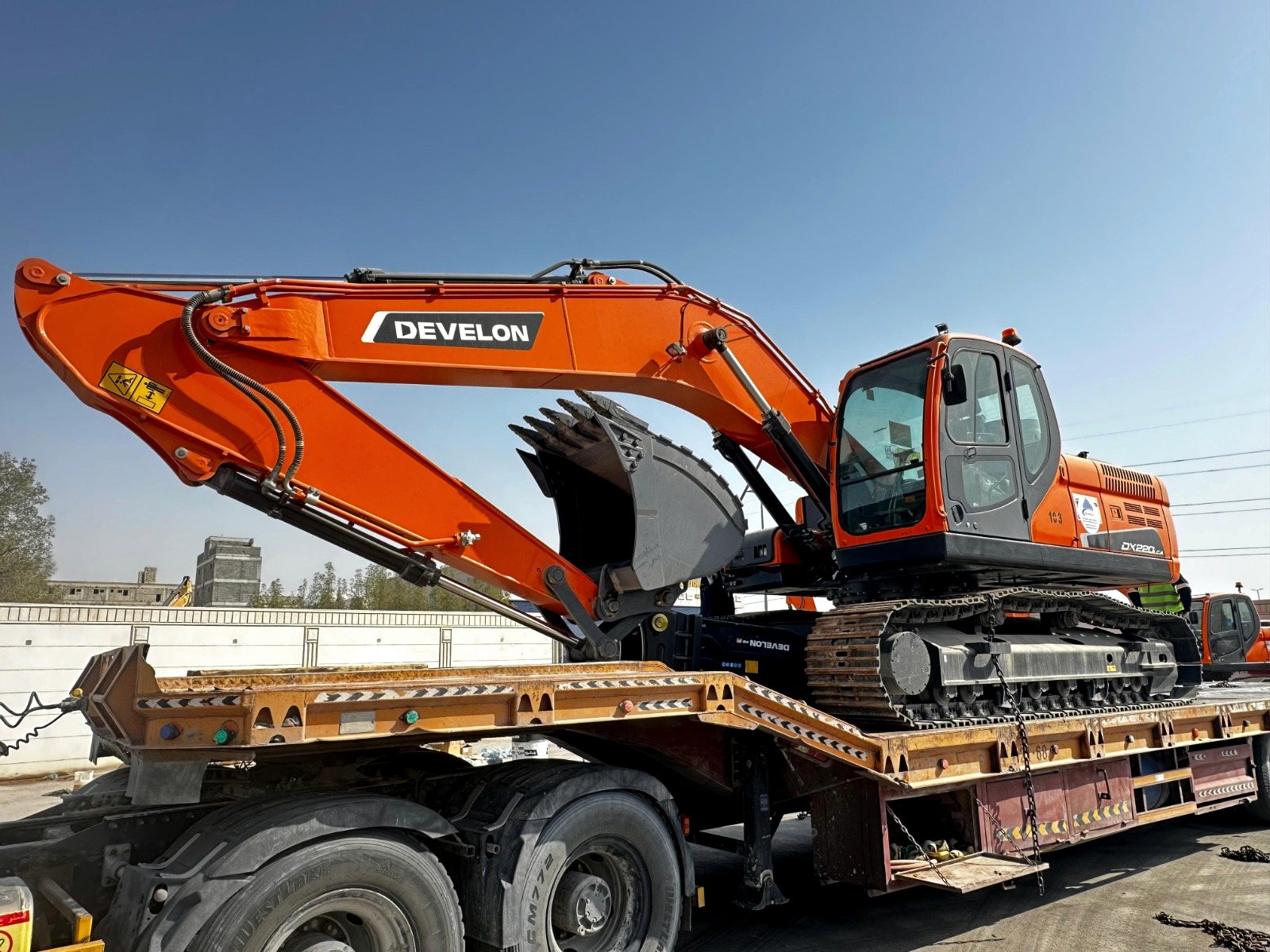 Excavator being loaded onto a low-bed trailer